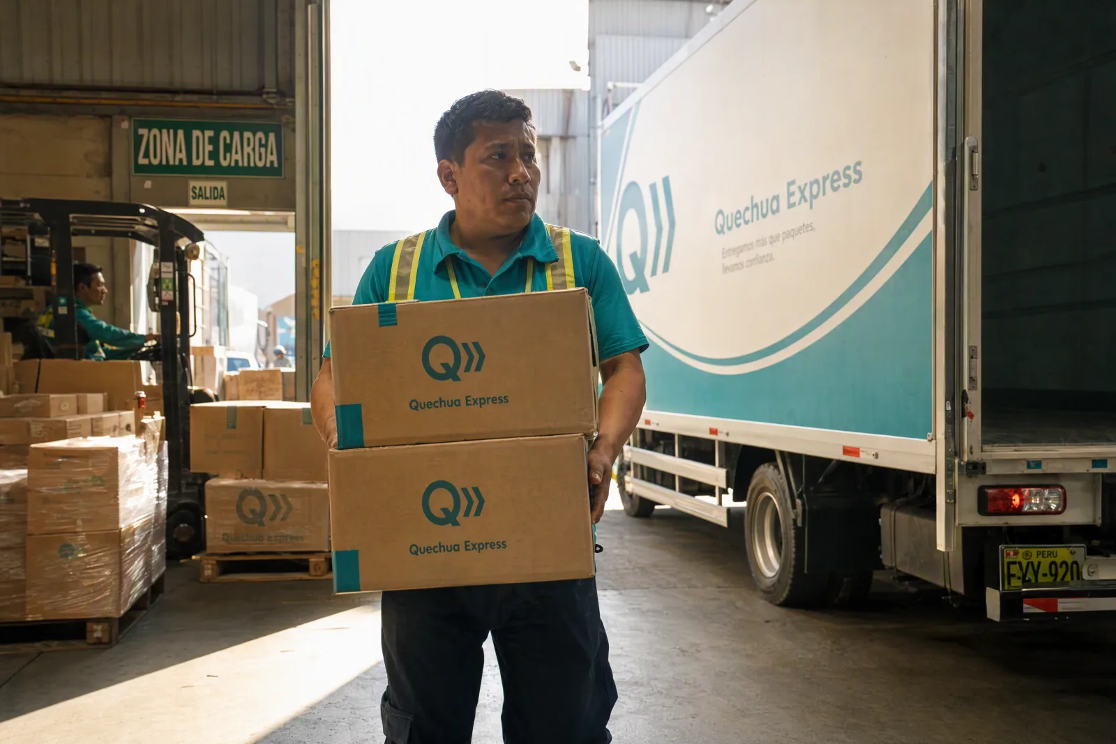 Personal de Quechua Express cargando paquetes en la zona de carga
